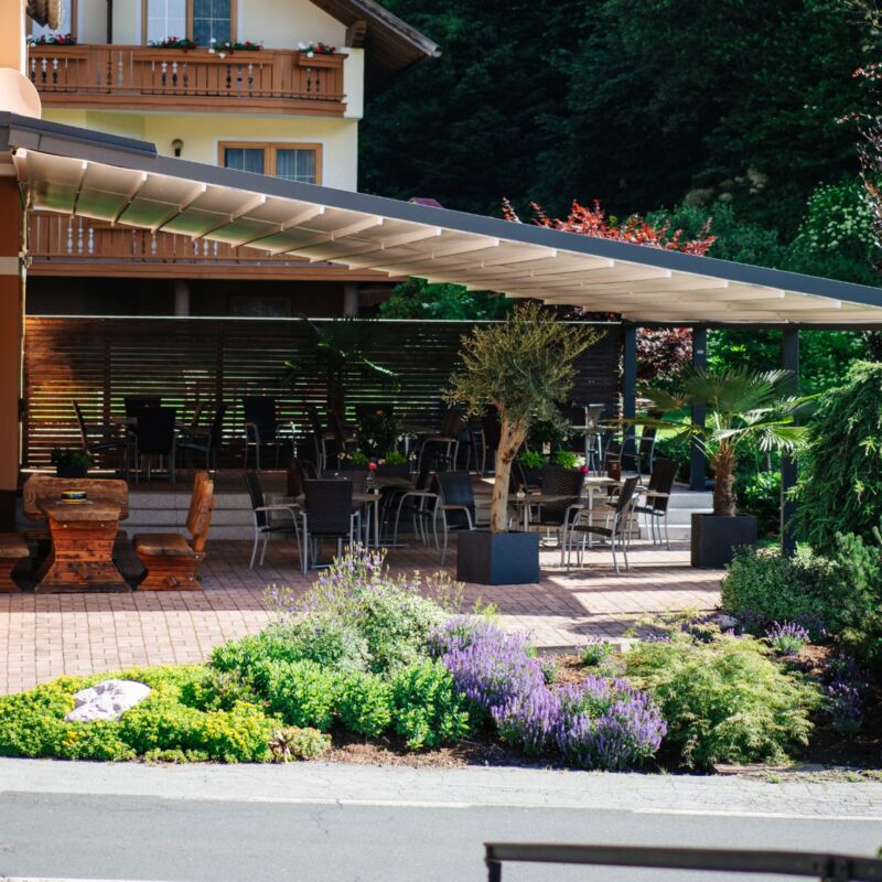 Sonniger Gastgarten mit eigener Terrasse im Hotel Gasthof Strasswirt am Nassfeld in Kärnten
